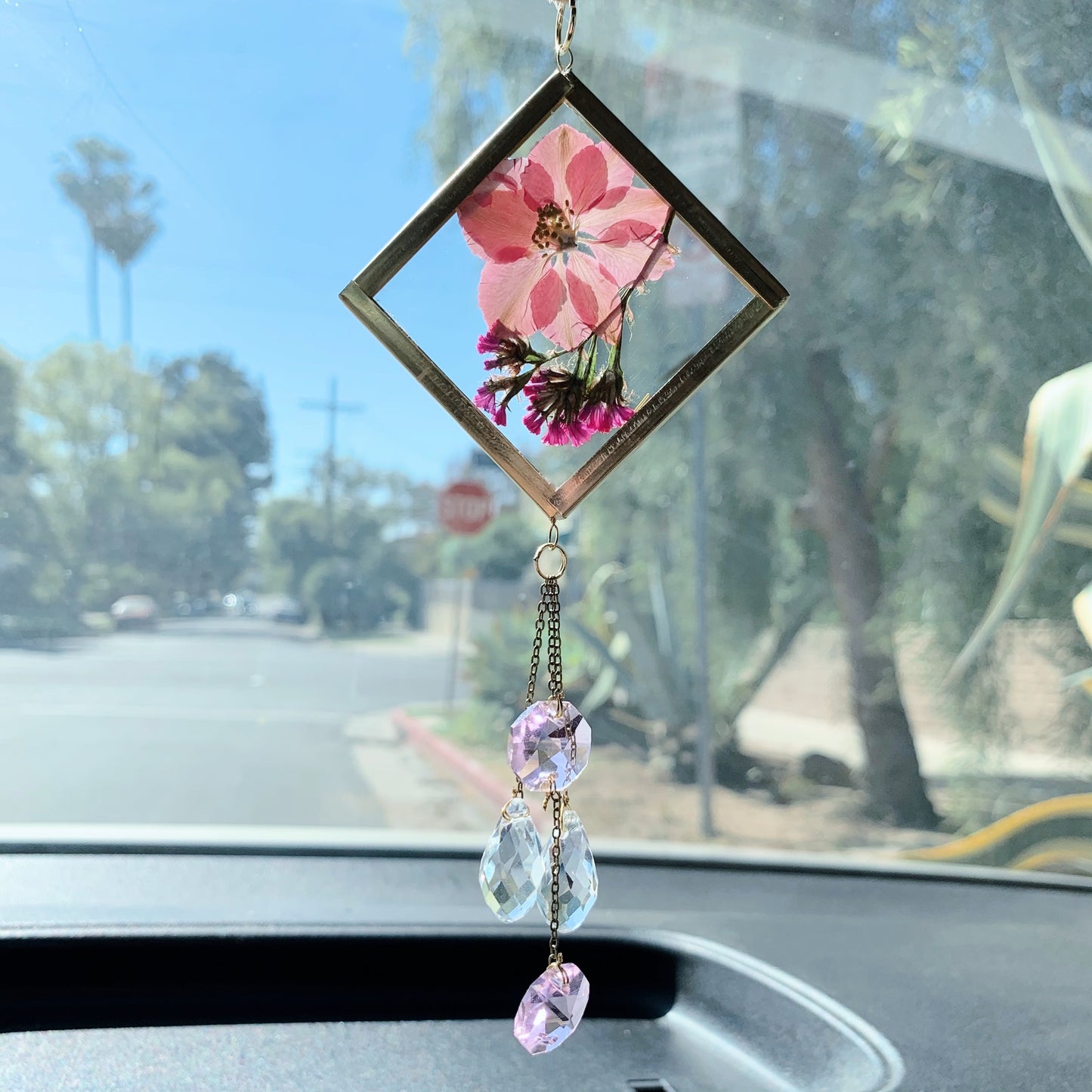 Pink cute car decor. A handmade sun catcher with pink pressed flowers and clear crystals, hanging from a car's rear view mirror.