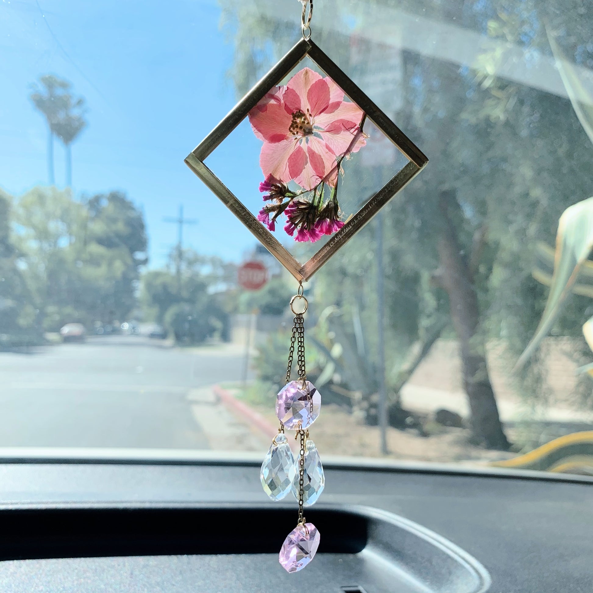 Pink cute car decor. A handmade sun catcher with pink pressed flowers and clear crystals, hanging from a car's rear view mirror.